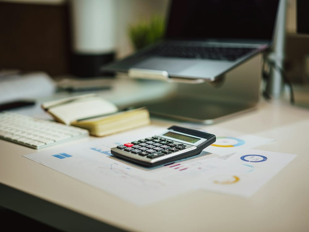 Calculator resting on financial reports at a desk